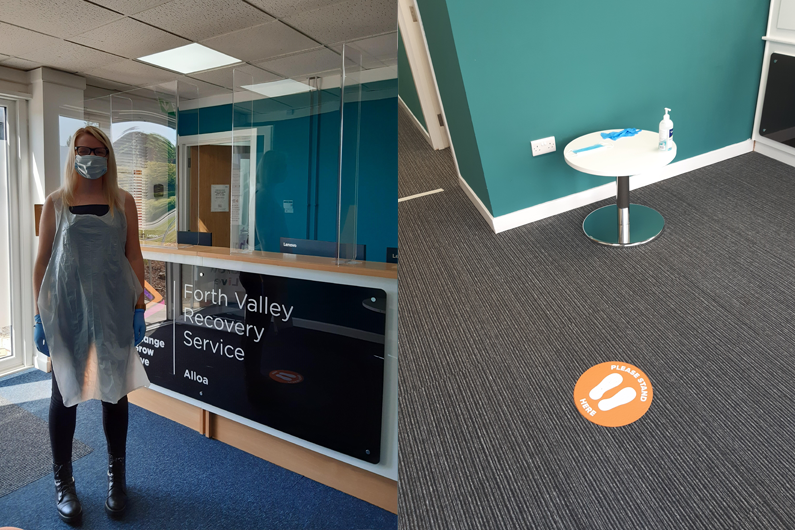 A member of our team in PPE and 2m safety signs in reception
